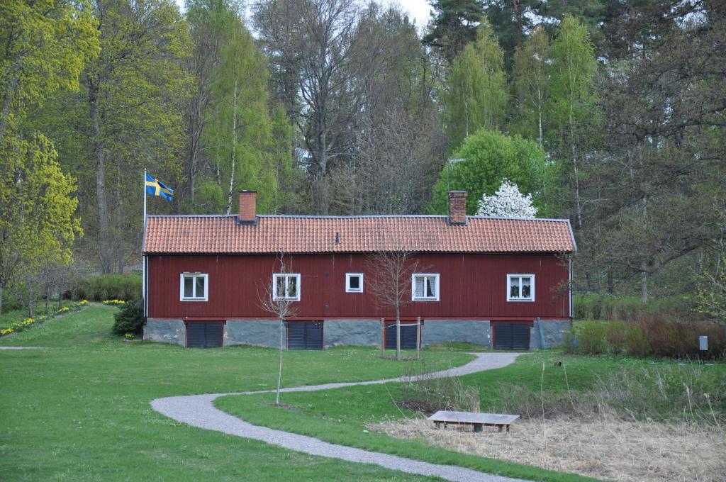 un granero rojo con una bandera encima en The Gardener House - Grönsöö Palace Garden en Grönsöö