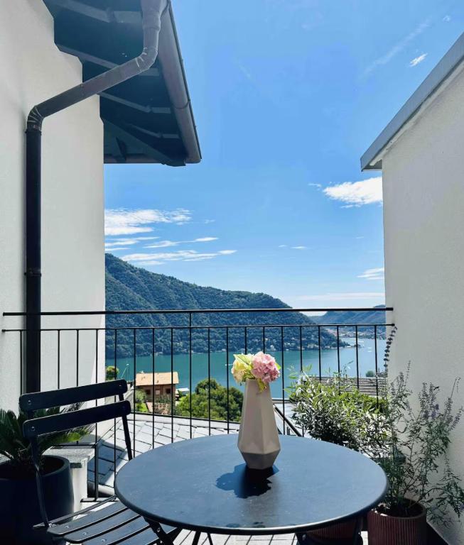 a vase with flowers sitting on a table on a balcony at Como Lake Dreamscape Villa in Cernobbio