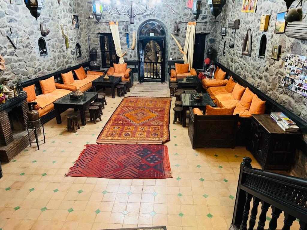 a room with orange chairs and carpets in a building at riad imlil in Imlil