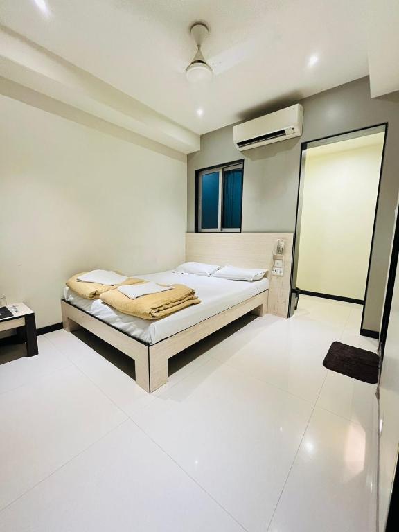 a white bedroom with a bed and a window at HOTEL MADNI ROYALE (50 Mtrs from Dargaah), Ajmer in Ajmer