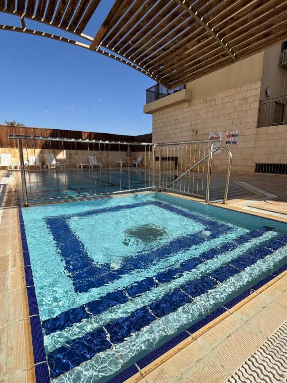 a swimming pool with blue water in a building at Kohav Sea View Penthouse in Eilat