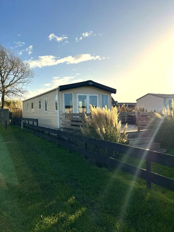 a house in a field with a fence at Chalet 91 Retro in Westerland