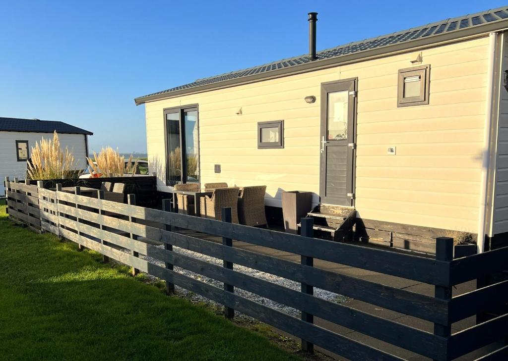 a fence with chairs in front of a trailer at Chalet 6 Wellenruh in Westerland