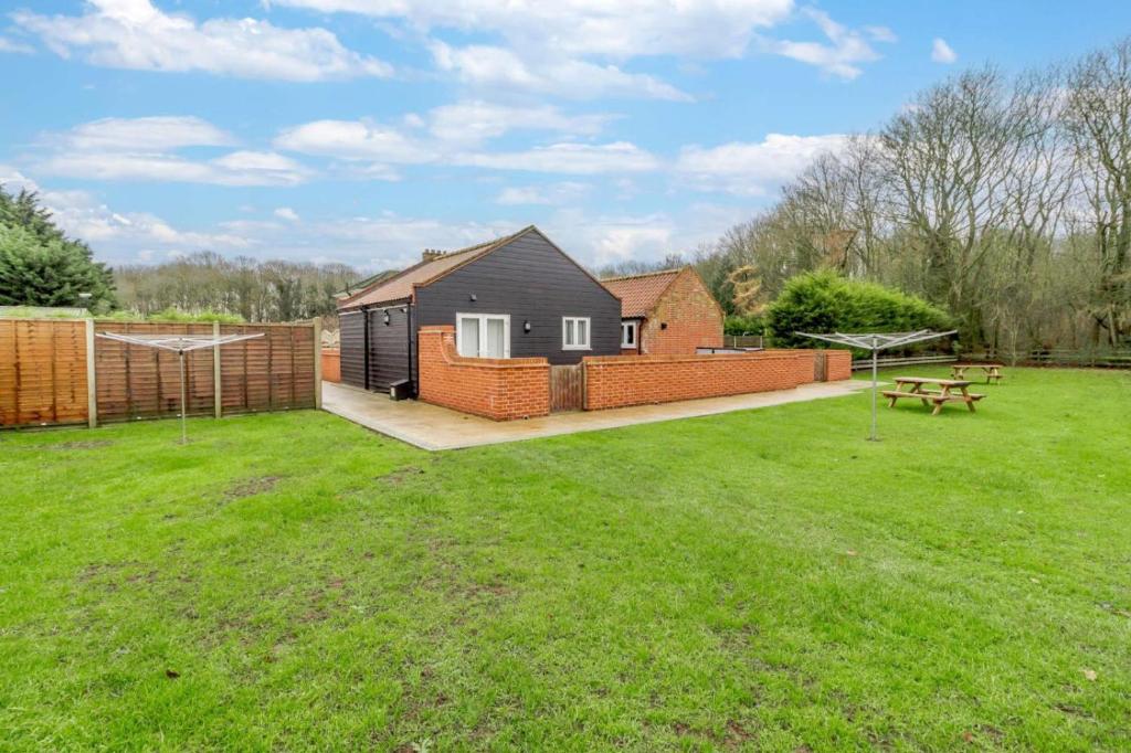 a backyard with a house and a picnic table at 5 Bed in Chedgrave oc-twcg in Chedgrave