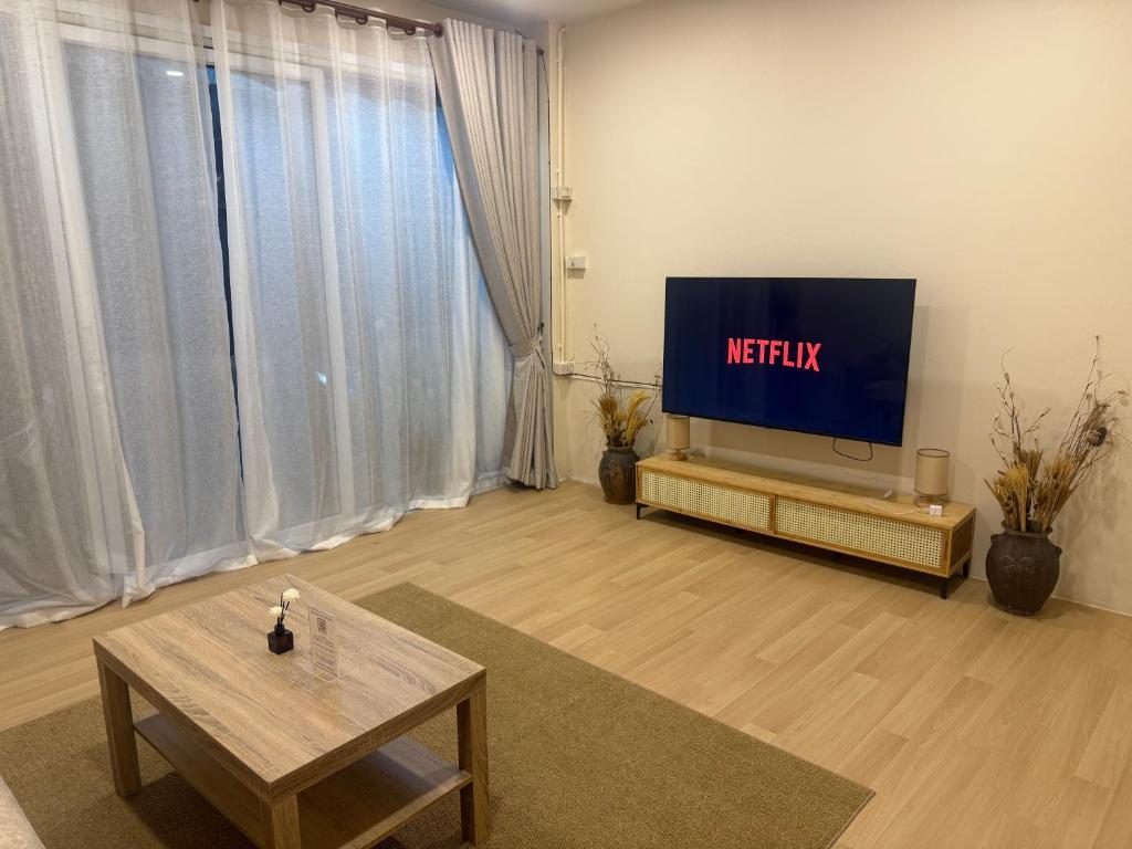 a living room with a tv and a table at Summer Sand in Haad Rin