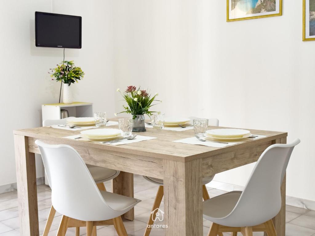 a dining room table with white chairs around it at Residenza Centrale in Villasimius