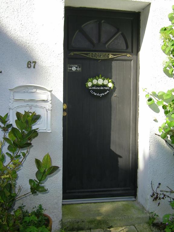 Une porte noire avec une couronne sur elle dans l'établissement La Colline des Roses, à Colline-Beaumont