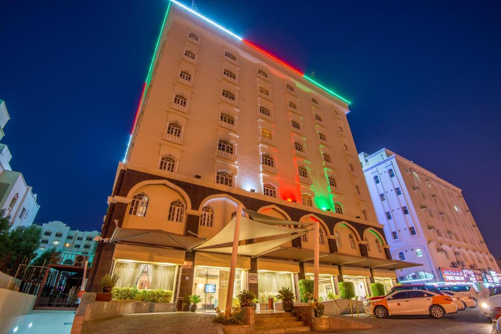 ein Hotelgebäude mit grünem und rotem Licht in der Unterkunft Caesar Hotel in Muscat
