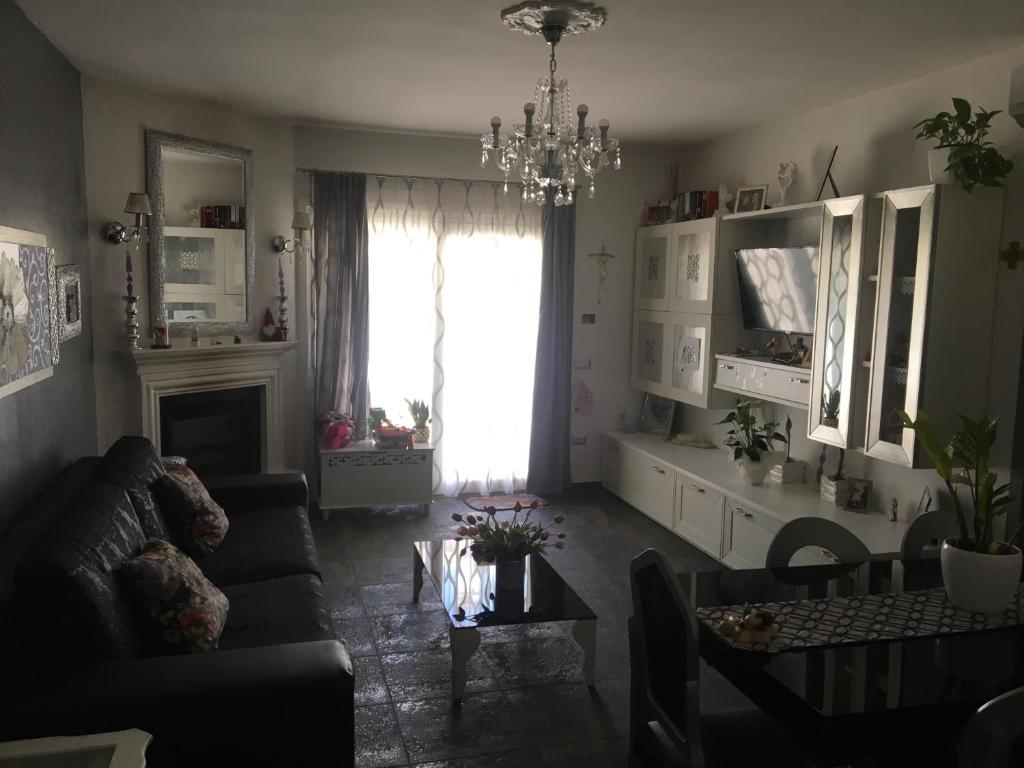 a living room with a couch and a chandelier at Acquamarina Luxury House in Budoni