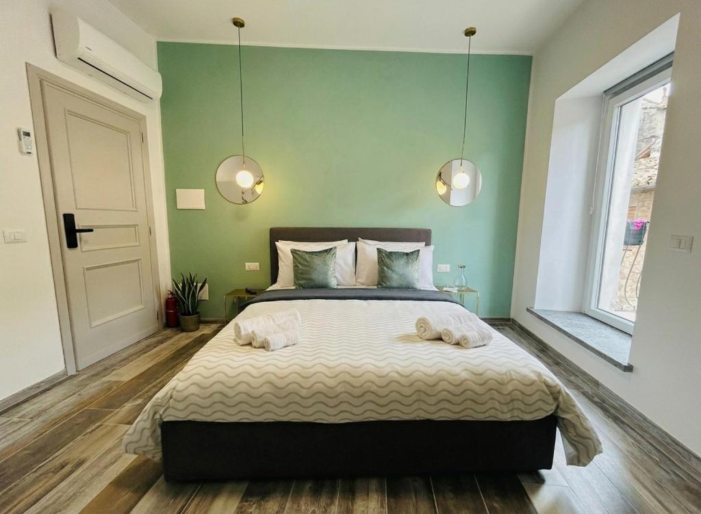 a bedroom with a bed with two towels on it at WelcHome Vitorchiano Guest House in Vitorchiano