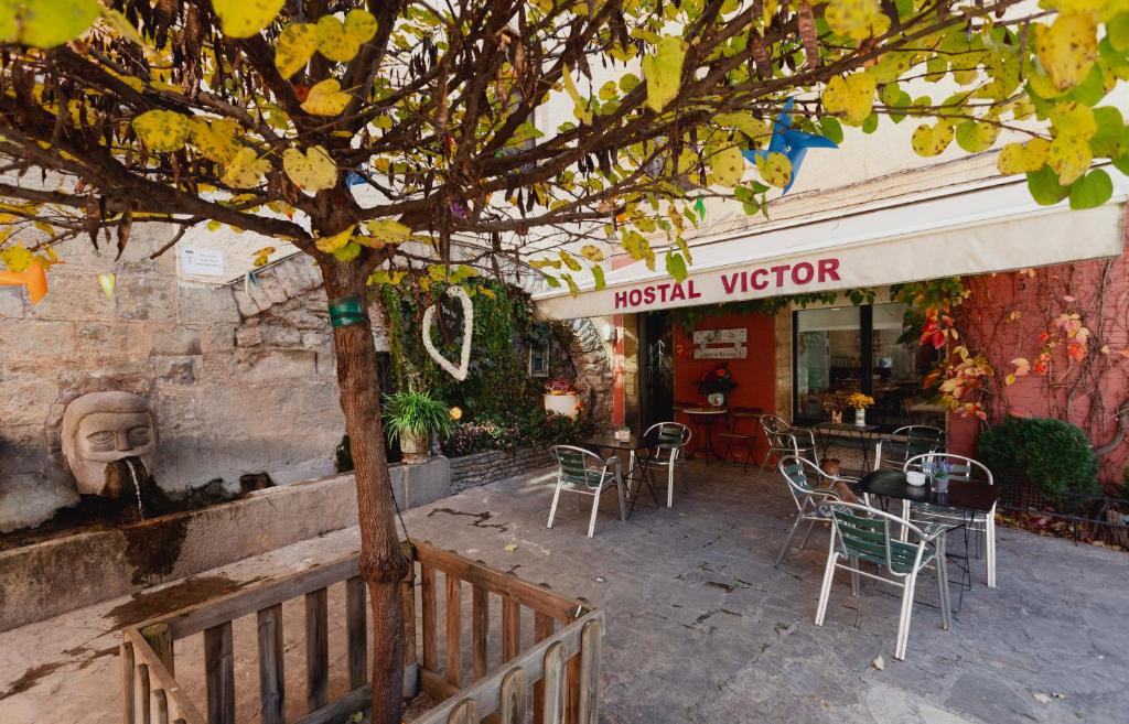 a restaurant with a table and chairs and a tree at Hostal Victor in Oliana