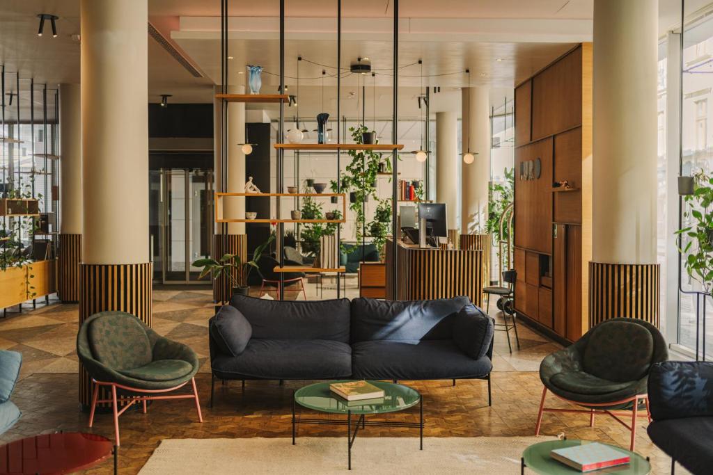 a living room with a couch and chairs at PURO Wrocław Stare Miasto in Wrocław