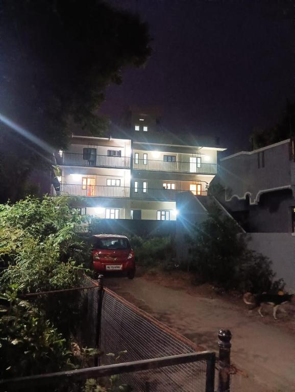 a car parked in front of a building at night at Joseph's Residency Homestay in Podanūr
