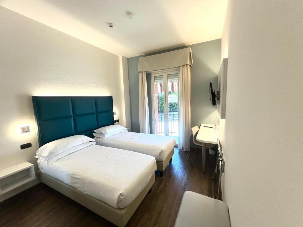 a hotel room with two beds and a window at Best Western Cesena Hotel in Cesena