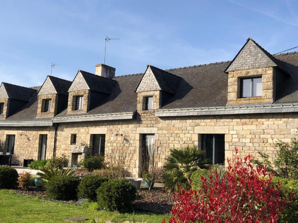 a large stone building with black roof at Entre terre et mer in Ploemeur