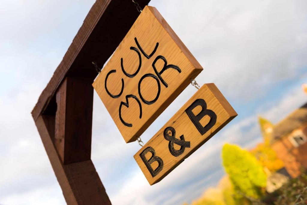 a couple of wooden signs hanging from a birdhouse at Cul Mor B&B in Eccleshall