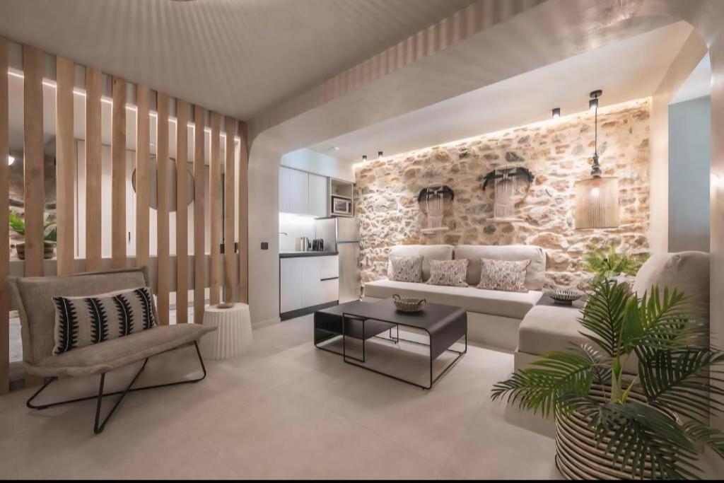 a living room with a white couch and a stone wall at Apollonos 28 Luxury Suites in Athens