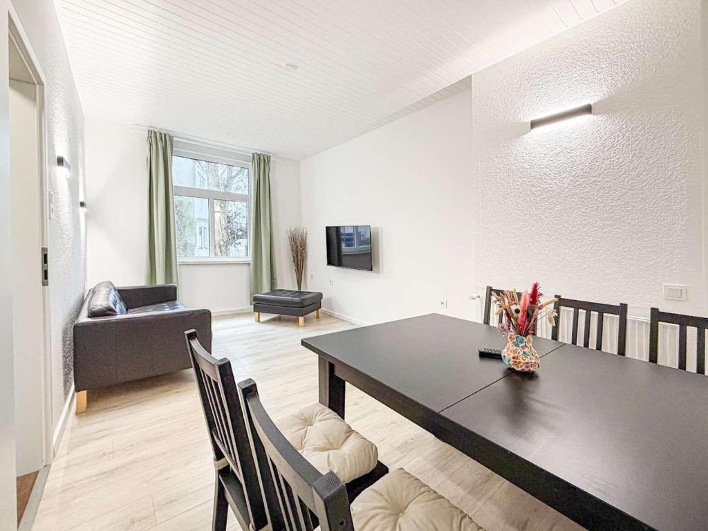 a dining room with a table and a living room at Emmas FEWO in Bremen
