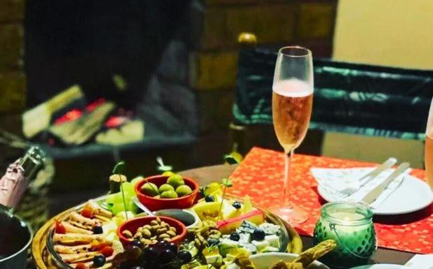 a table with a plate of food and a glass of wine at Pousada Bocaina in São Pedro da Serra
