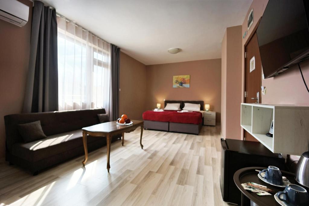 a living room with a couch and a bed at Hotel Leda in Sofia