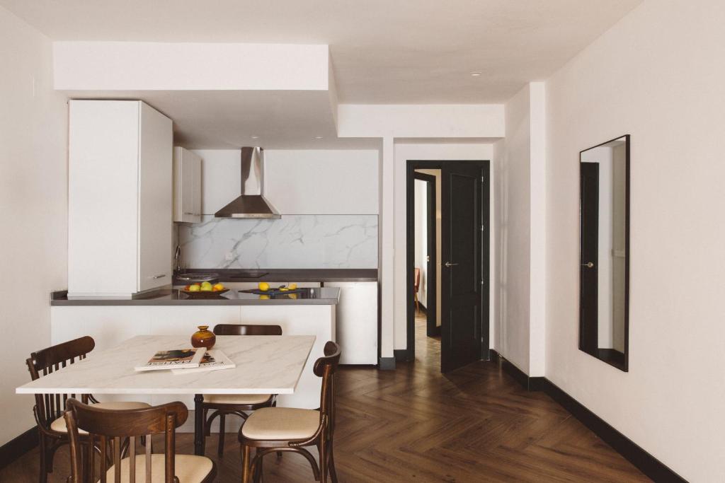 a kitchen and dining room with a white table and chairs at Honest Granada Apartments in Granada