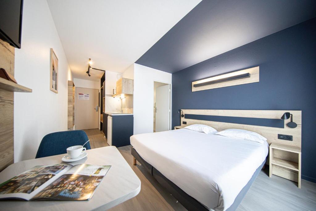 a hotel room with a bed and a table at City Résidence Nancy in Nancy
