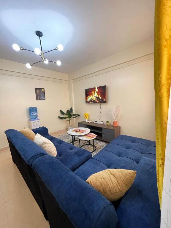 a living room with a blue couch and a table at Cosy Loft Eldoret in Eldoret