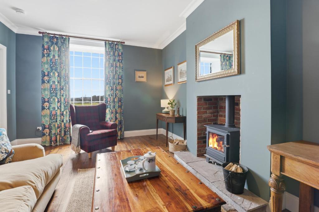 a living room with a couch and a fireplace at Lantern House - North East Escapes in Belford