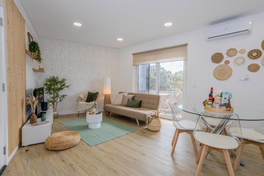 a living room with a glass table and a couch at Nono Guest House in Ribeira Grande
