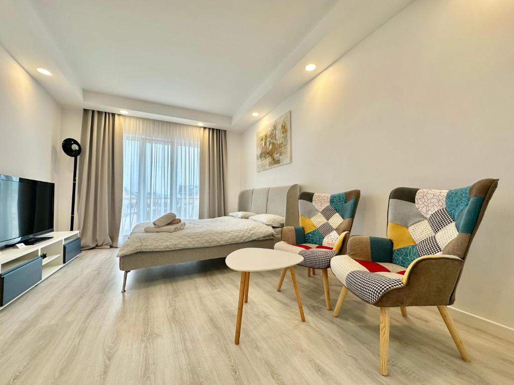 a living room with two chairs and a couch at Anturium Studio #Otopeni #freePool in Tunari