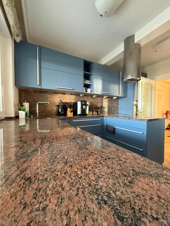 a kitchen with blue cabinets and a granite counter top at Dünenhaus Garten in Timmendorfer Strand