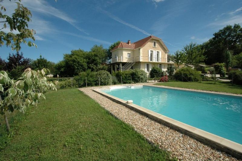 a house with a swimming pool in front of a house at La Tulipe Périgourdine in Le Buisson de Cadouin