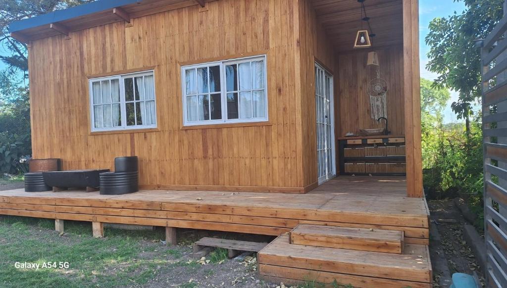 a wooden cabin with a porch and two windows at Cabaña Tu Refugio in Paraná