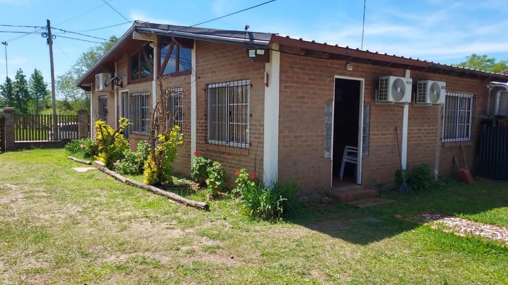a brick house with an open door in a yard at Departamento Rincon de Paz in Colón