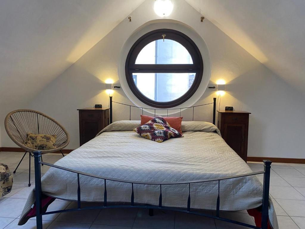 a bedroom with a bed with a large window at La mansardina del mulino in Lodi