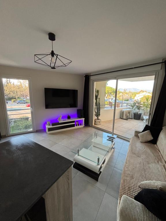 a living room with a couch and a table at Appartement 2 pièces in Fréjus