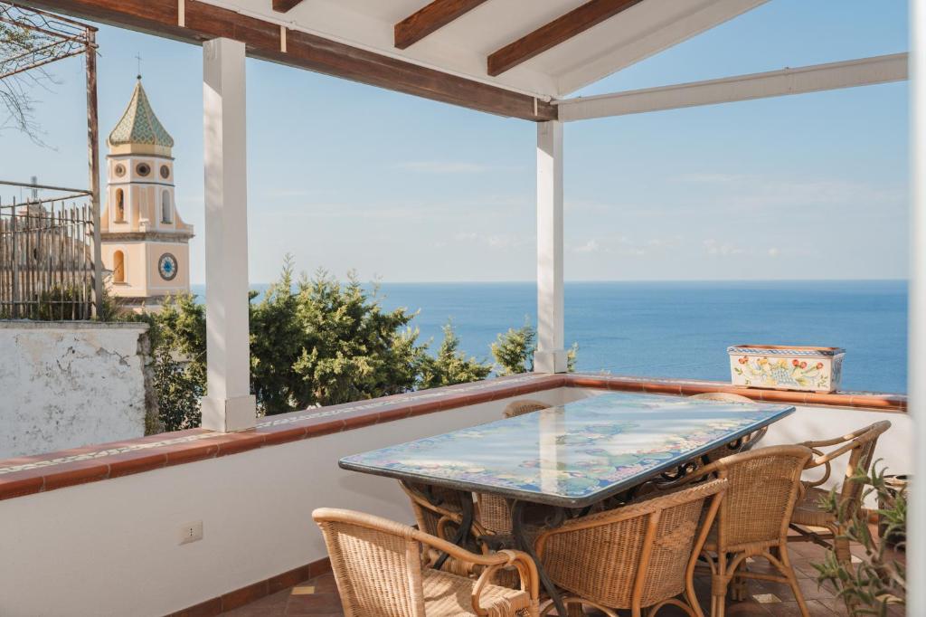 a table on a balcony with a view of the ocean at Casacasa Praiano in Praiano