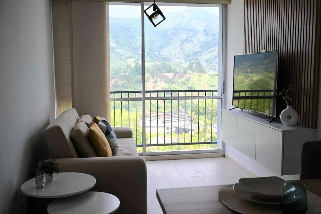 a living room with a couch and a large window at Posada del Quindío 0812 in Armenia