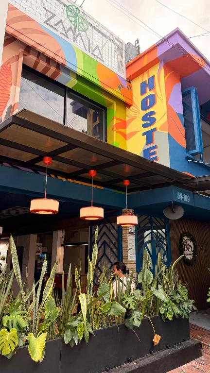 a person sitting outside of a colorful building at Zamia Hostel in Bucaramanga