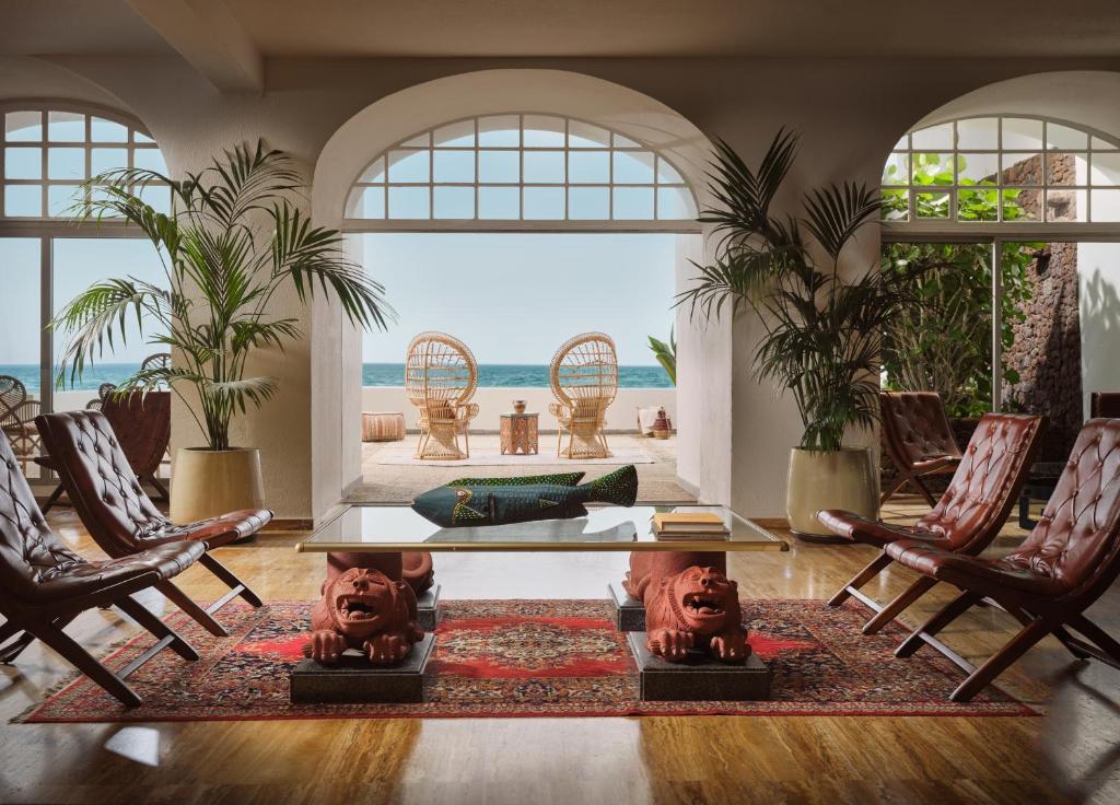 ein Wohnzimmer mit Tisch und Stühlen und dem Meer in der Unterkunft Precise Resort Tenerife in Puerto de la Cruz
