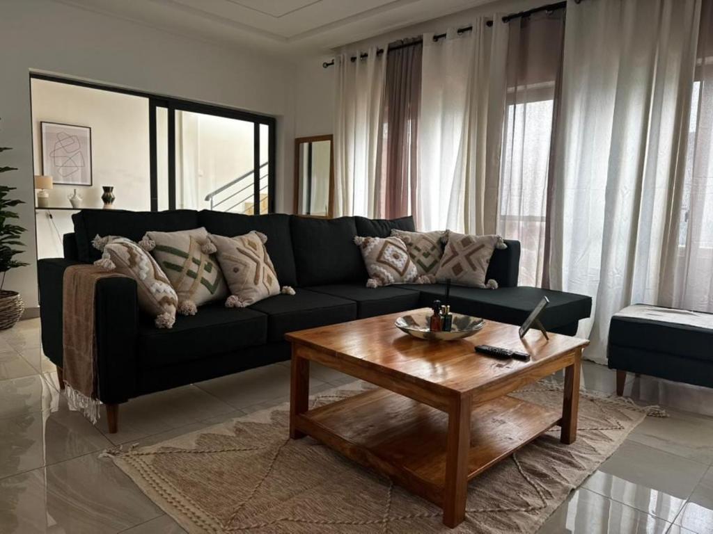 a living room with a black couch and a coffee table at Villa EWA in Cotonou