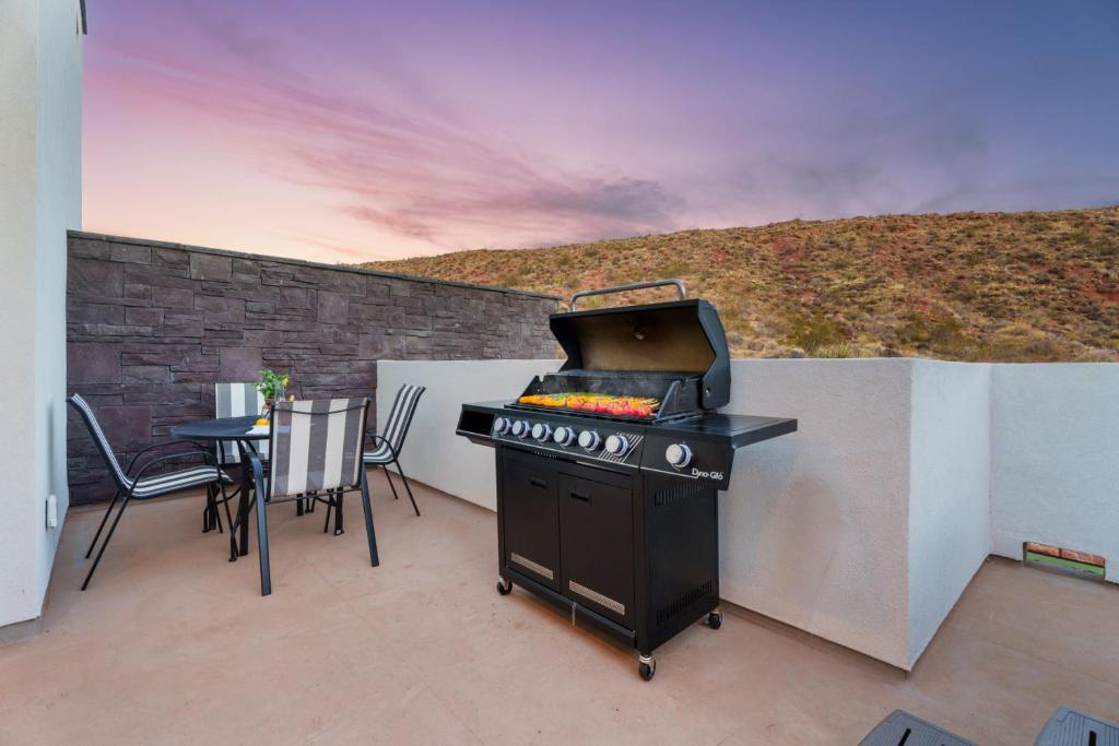 a grill on a patio with a table and chairs at Sunny Springs, Hurricane, Ut in Hurricane