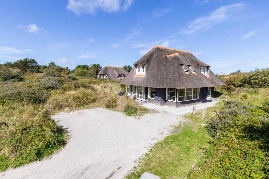 an aerial view of a house with a thatched roof at Luxe Duinvilla Stern met sauna voor 8 personen nabij strand en dorp Nes in Buren