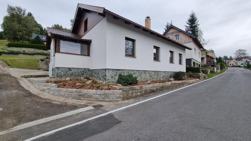 a white house on the side of a road at Prázdninový dům u Špičáku in Albrechtice v Jizerských horách