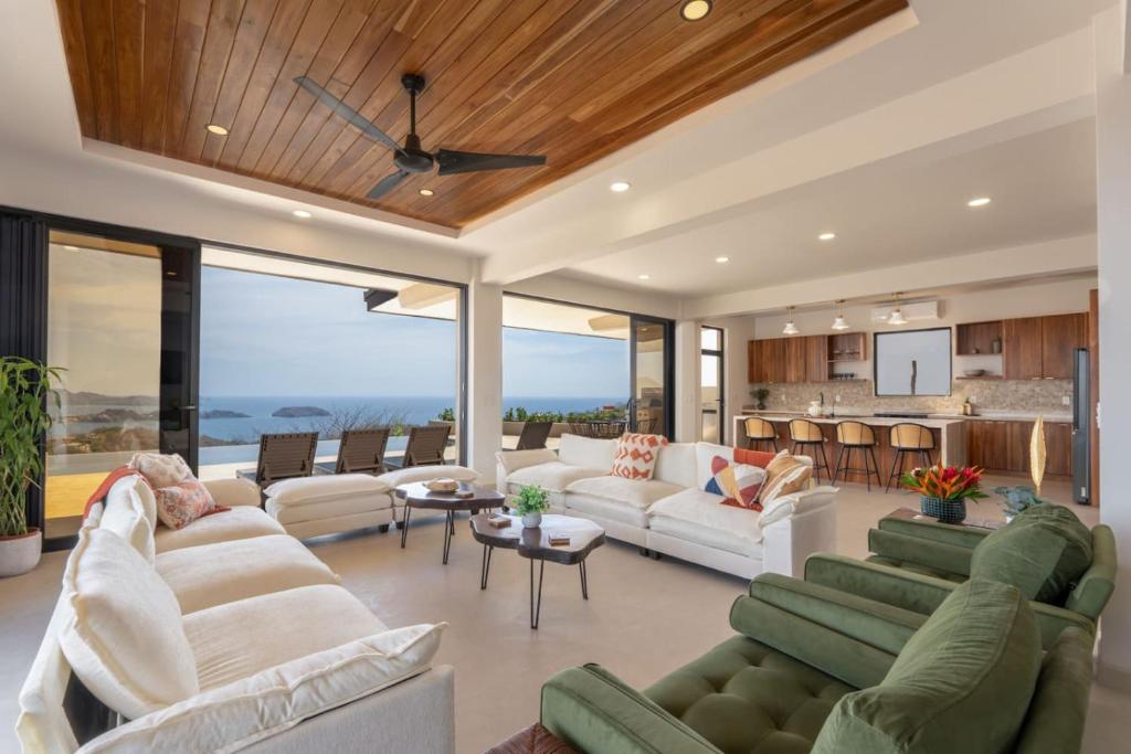 a living room with white furniture and a kitchen at NEW! Oceanview, Infinity Pool, Spacious & Private Luxury Group Retreat in Potrero