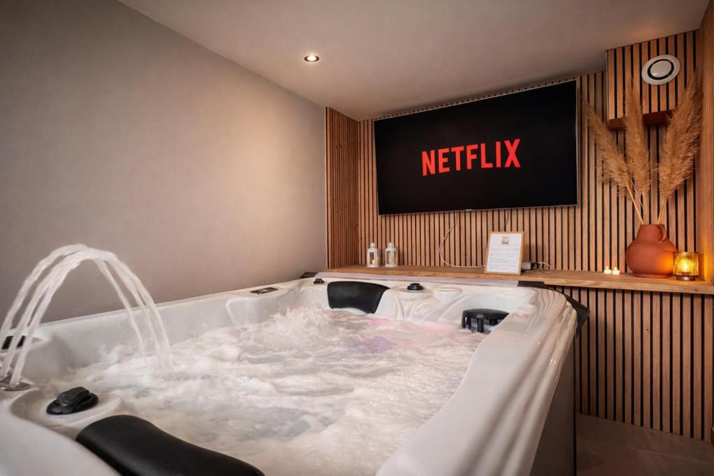 a jacuzzi tub in the corner of a bathroom at L'Amaryllis, suite romantique Jacuzzi et Parking in Cintegabelle