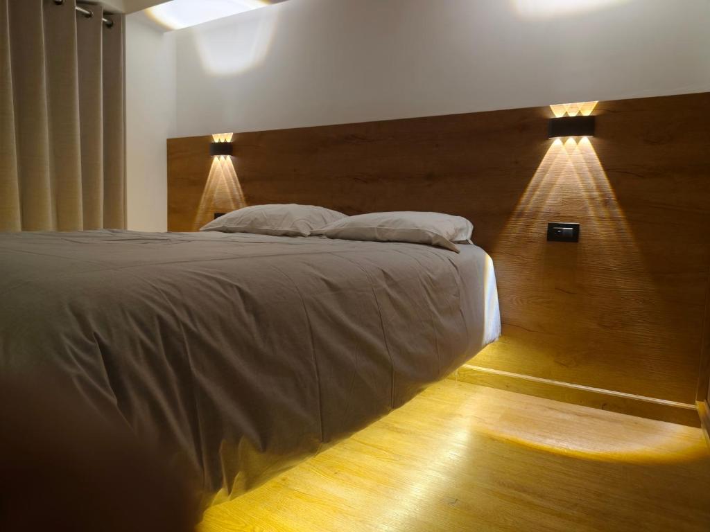 a bedroom with a large bed with two lights on it at Casa Karmenka in Cusco