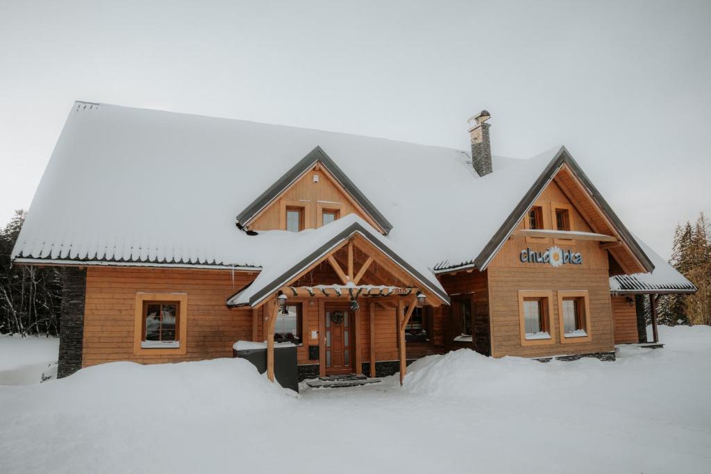 a log cabin in the snow with snow around it at Chalupa Chudobka in Janske Lazne