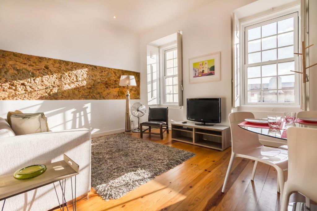 a living room with a bed and a dining room at São Mamede Downtown Apartment in Lisbon