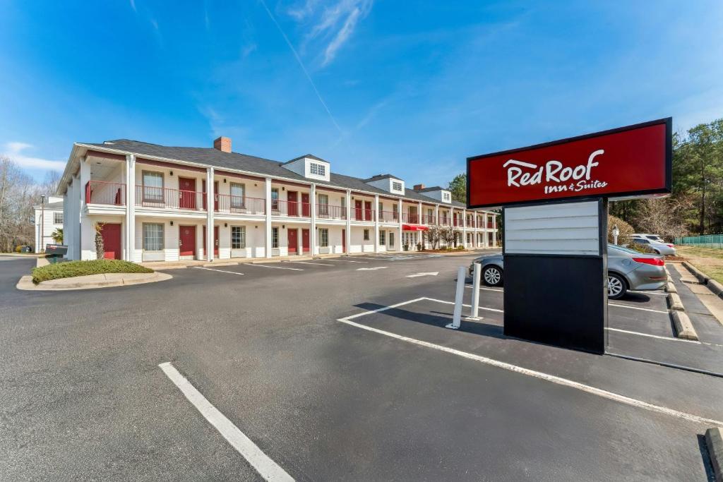 a hotel with a sign in front of a building at Red Roof Inn & Suites Wilson in Wilson